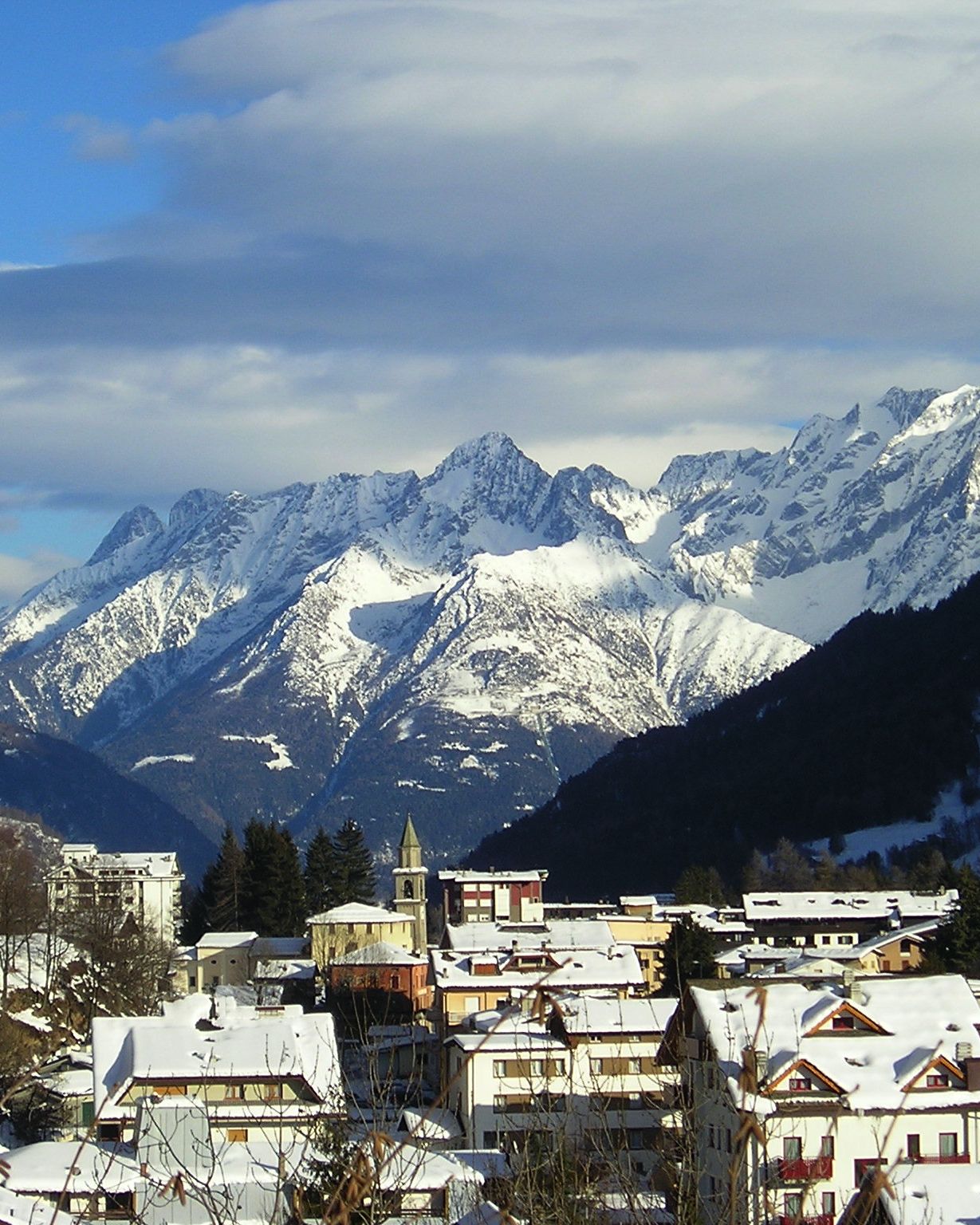 Aprica sotto la neve con il campanile e il gruppo dell'Adamello