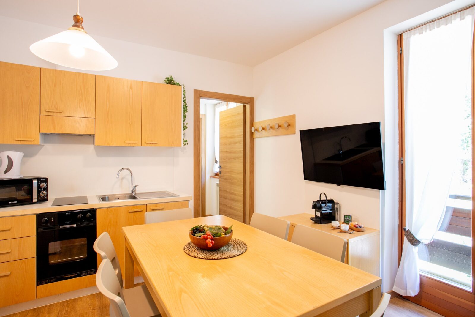 Cucina e zona pranzo con la porta sul balcone